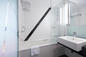 伯尔尼伯尔尼韦斯特赛德假日酒店的白色的浴室设有水槽和淋浴。