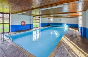比尔斯韦尔斯Kestrel Cottage的一座带木制天花板的大型室内游泳池