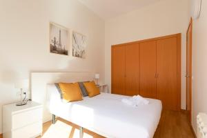 巴塞罗那AB North Barcelona Apartments的卧室配有白色的床和木制橱柜。