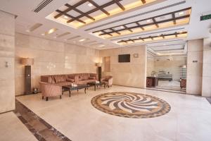 麦加Al Hidayah Towers Hotel的带沙发、电视和地毯的大堂
