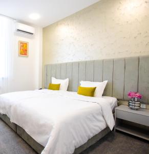 埃里温Benefice Hotel Yerevan的卧室配有一张带黄色枕头的大型白色床。