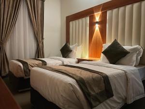 吉达Staytion Express Orjwan Lebanon的酒店客房设有两张床和窗户。