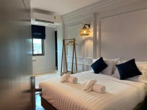 清迈Wiang Ville Boutique Hotel的一间卧室配有一张大床和毛巾