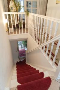 柏林Hotel Petit Wannsee的一座房子里铺着红地毯的楼梯
