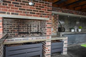 贝尔维尔OnQ Accommodation的厨房设有砖砌壁炉和水槽。