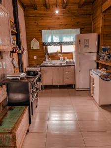 邦雅尔丁-达塞拉Chalé Guadalupe - Condomínio Altos da Serra的厨房配有冰箱和炉灶。