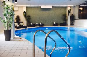 哥德堡温恩品质酒店的酒店大堂的大型游泳池,设有蓝色的游泳池