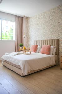 拉巴特YourPlace - Luxury - Prestigia Hay Riad的卧室配有带粉红色枕头的大型白色床