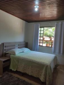 伊瓜苏Suíte Maciel的一间卧室设有一张床和一个窗口