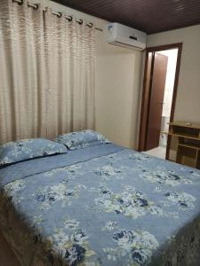 伊瓜苏Suíte Maciel的一间卧室配有一张带蓝色棉被的床