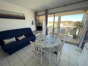 米尼赞海滩Le Surf的客厅配有蓝色的沙发、桌子和椅子