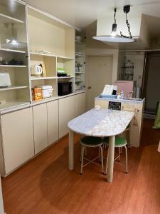 东京Palette Takashimadaira guest house的厨房配有桌子和两把椅子