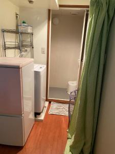 东京Palette Takashimadaira guest house的厨房配有冰箱和浴帘