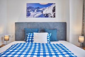 加尔米施-帕滕基兴BergZeit的一间卧室配有一张带蓝白色 ⁇ 面毯的床