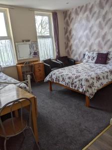 大雅茅斯克里斯伍德贵宾酒店的卧室配有一张床和一张桌子及椅子
