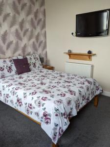 大雅茅斯克里斯伍德贵宾酒店的一间卧室配有一张带花卉床罩的床