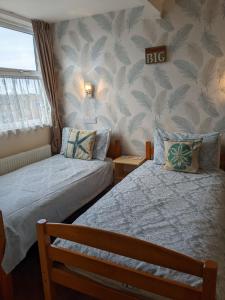 大雅茅斯克里斯伍德贵宾酒店的一间卧室设有两张床,墙上有树叶