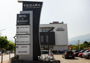 普里兹伦Hotel Tesara的停车场内有车辆的建筑物