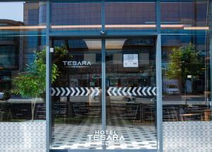 普里兹伦Hotel Tesara的酒店配有桌椅的玻璃窗