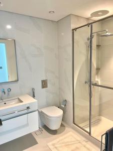 迪拜Luxurious Beachfront Apartment的带淋浴、卫生间和盥洗盆的浴室