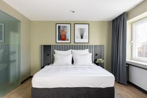 波恩numa I Bona Rooms & Apartments的一间卧室设有一张大床和两个窗户。
