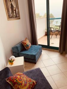 提比里亚טבריה的一间带蓝色沙发的客厅和一个阳台
