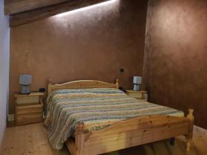 苏萨Agriturismo al pra di muriet的一间卧室配有木床和2个床头柜