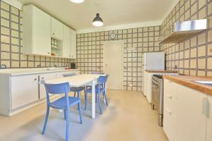 卡波利韦里Villa Elle Exclusive Isola d'Elba的厨房配有白色的桌子和蓝色的椅子