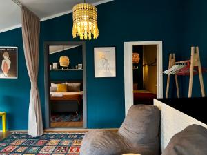 普里什蒂纳Light and Bright Central的客厅设有蓝色的墙壁和吊灯。