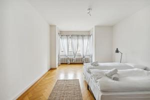 苏黎世Central Apartment for City Explorers 224的白色客房,配有两张床和地毯