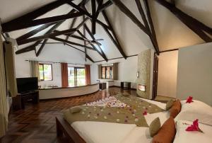 Ambaro拉文萨拉疗养酒店的大型客房,地板上设有两张鲜花床