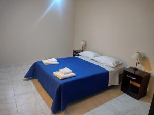 图努扬La Candida的一间卧室配有蓝色的床和毛巾