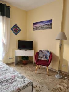 圣雷莫Casa dell amore 2的一间卧室配有书桌、椅子和电视。