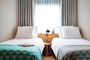 伦敦伦敦好酒店的配有窗户的酒店客房内的两张床