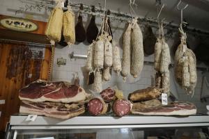 基安蒂盖奥勒Osteria Carnivora Guest House的商店里肉和其它食物的展示