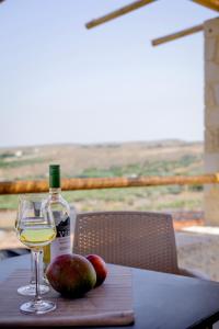 StíronasAlagni Cretan Resort的一瓶葡萄酒和一些苹果放在桌子上