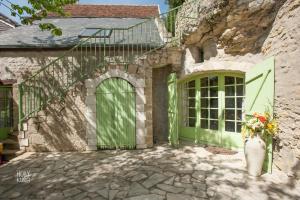 Civray-de-TouraineSongbird Sanctuary的一座石头房子,有一道绿门和花瓶