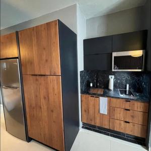 圣胡安Moderno Apartamento para parejas San Juan Puerto Rico的厨房配有不锈钢冰箱和木制橱柜