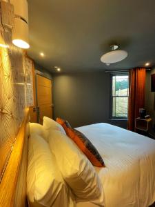 斯特兰福德Lough Rooms at The Artisan的一间卧室配有带白色床单和枕头的床。