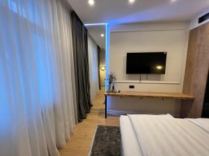 萨格勒布SDesign Luxury Zagreb apartment的配有一张床和一台平面电视的酒店客房