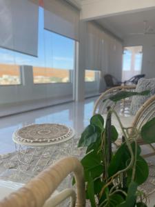 Al WāşilHome X4的一间设有玻璃桌和植物的餐厅
