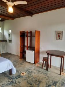 库穆鲁沙蒂巴Pousada Cantoria的客房设有一张床、一张桌子和一张书桌。