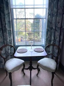 托特尼斯Luxury flat in Totnes的窗前的一张桌子和两把椅子