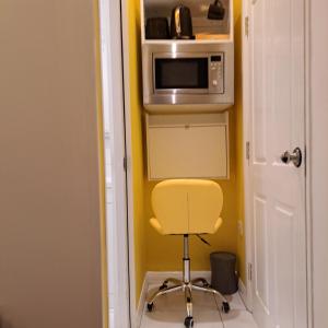 布里斯托Lovely and Modern Groundfloor 1 Single Bedroom Condo with Netflix, Tea/Coffee/Biscuits的微波炉间里的黄色椅子