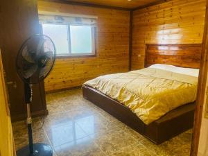ZūbiyāGreen House的一间卧室配有一张床和一个风扇。
