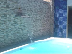 尼泰罗伊Casa Piscina em Condomínio 5min Praia ITACOATIARA.的浴室设有浴缸及喷泉