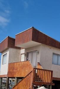 巴伊亚英格莱萨Cabañas Aquila D'Arroscia的一座带木甲板和蓝天的房子