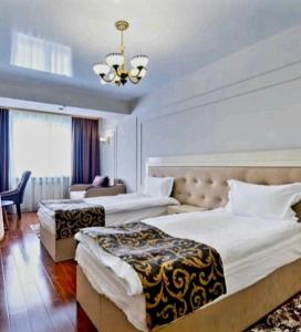 阿拉木图LAMIYA Aparts Hotel的酒店客房设有两张床和吊灯。