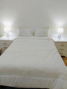 瓜亚基尔Spacious 2-Bedroom Condo in Bellavista, Guayaquil的一间卧室配有白色床和2个床头柜
