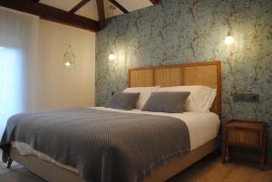 庞特维德拉Hotel a Ecogranxa的一间卧室配有一张带蓝色壁纸的大床